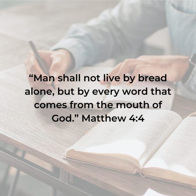 Man writing on notepad with caption "Man shall not live by bread alone, but by every word that comes from the mouth of God." Mathew 4:4